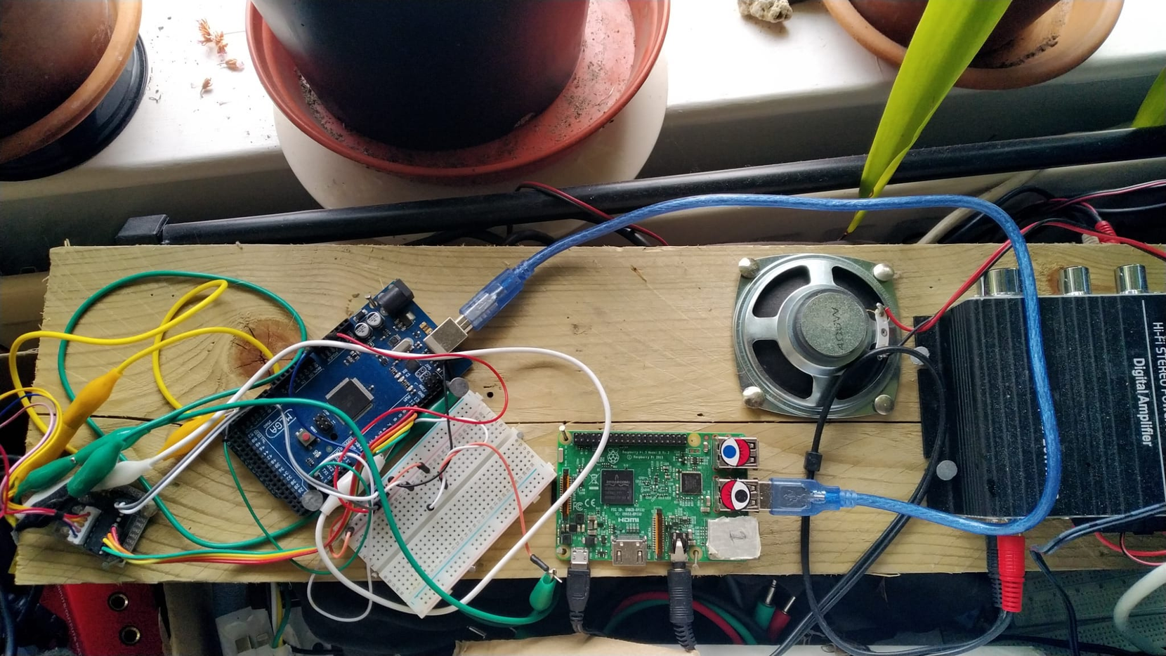 Photo depicts a view looking down onto the contents of the top of the apparatus that drive the movements and sound of the bird in Bird on a Wires.