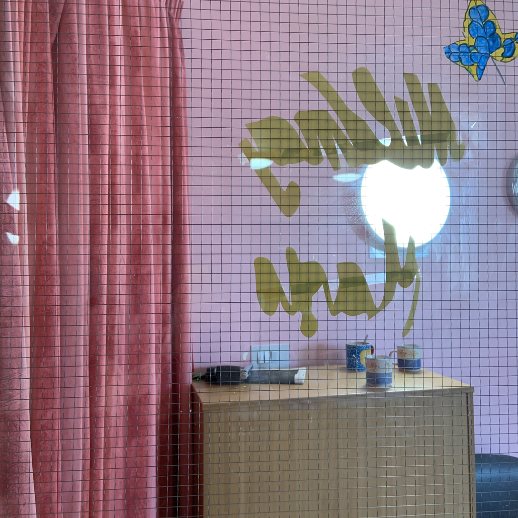A picture of the glass pane in an internal door of the care home with the words Mildmay written backwards on a paper cut out
