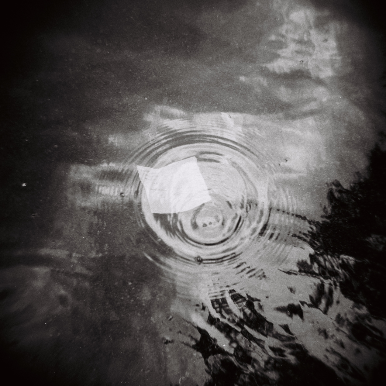 Valkoinen runopaperi vedessä, pyörteen sisällä.