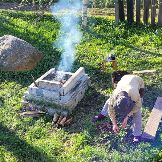 Picture of a person picking trash off the ground around a fireplace.