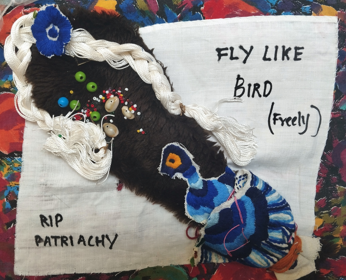 3 d doll-ish figure sewn onto fabric