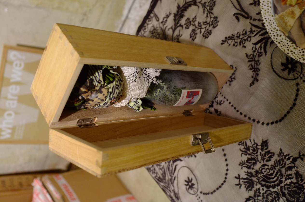 A photo of an art object inside a tall wooden box.