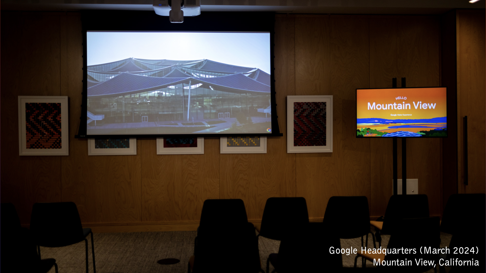 A construction site of the Google Data Center in Sparks, NV. A utility pole and rocks in the left foreground. Construction cranes and mountains in the background.