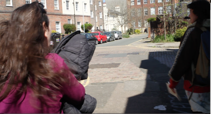 A photo of the back of two women walking down a street,