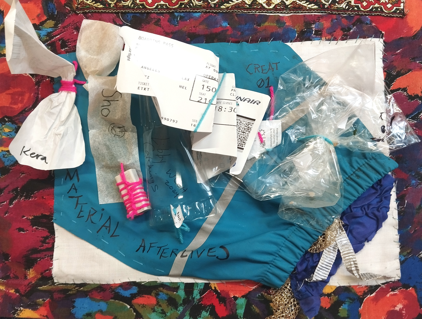 garbage affixed to turquoise rain jacket ontop of white background