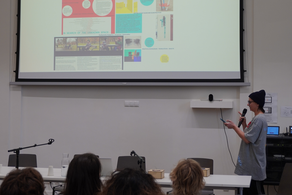 Photo from the prize winner Ingrid Cogne in front of a digital collage of her exposition screened on the wall.