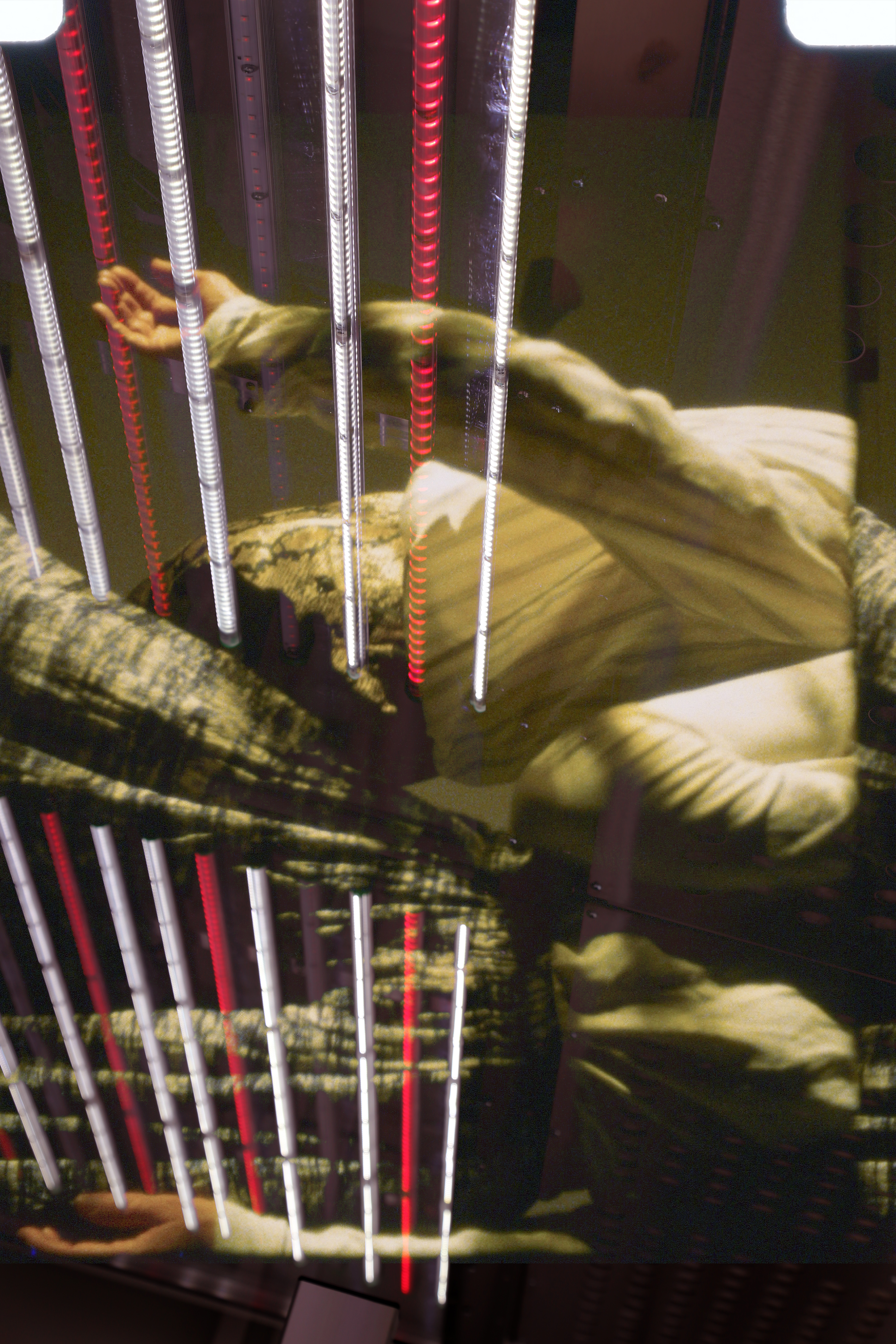 Collage of two-color images: closeup of two female bodies moving and white and red light bulbs overlaid.